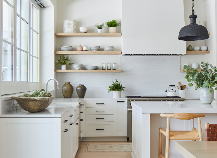 Stainless steel open shelves displaying stylish cookware and decorative items.