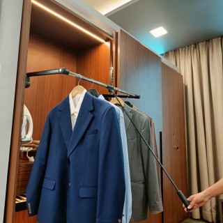 A pull-down side mount in a wardrobe, allowing easy access to high-hanging clothes.