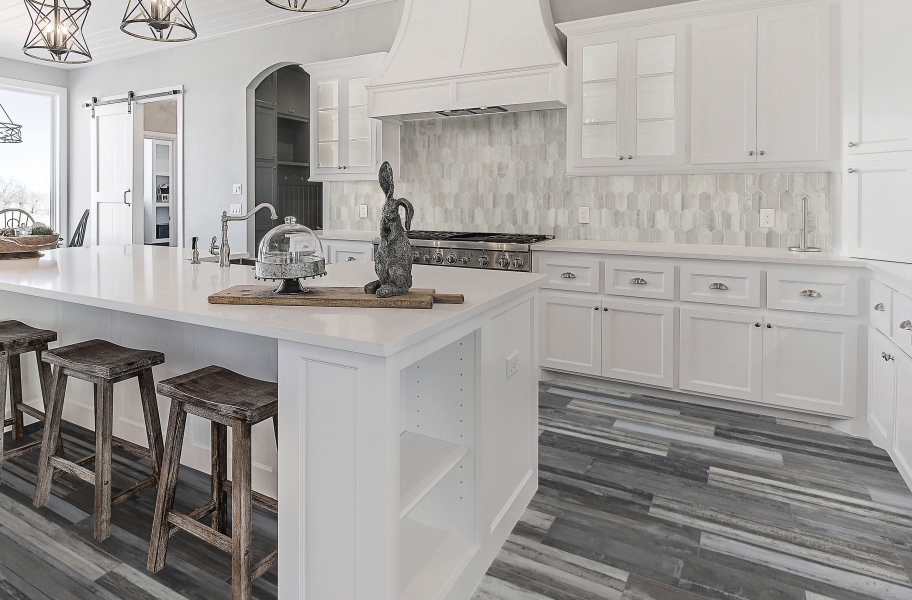 Patterned ceramic tiles adding warmth and personality to a stainless steel kitchen.