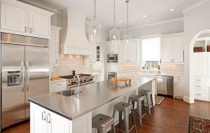 Modern kitchen with stainless steel elements and quartz countertops.
