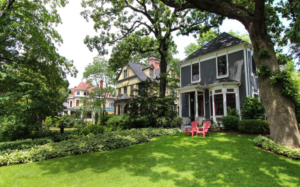 A well-landscaped home surrounded by trees, demonstrating the increase in property value.